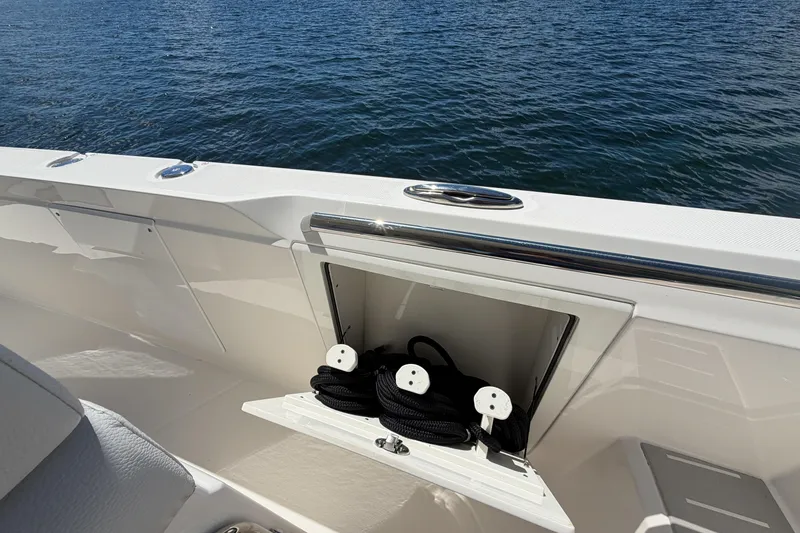 Slide: The Image of 2024 Tiara Yachts 43 LS boat with open storage compartment and ropes, on calm water. - 26
