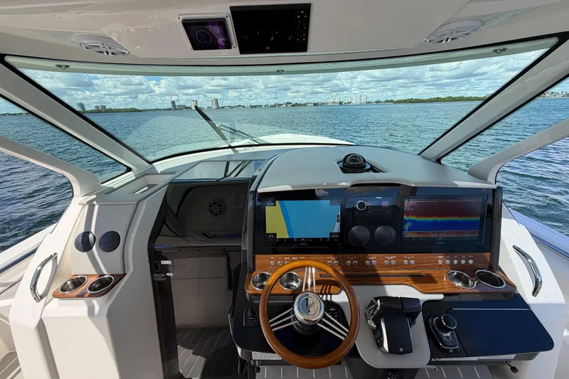 Slide: The Image of 2024 Tiara Yachts 43 LS helm with advanced navigation displays and wooden steering wheel. - 27