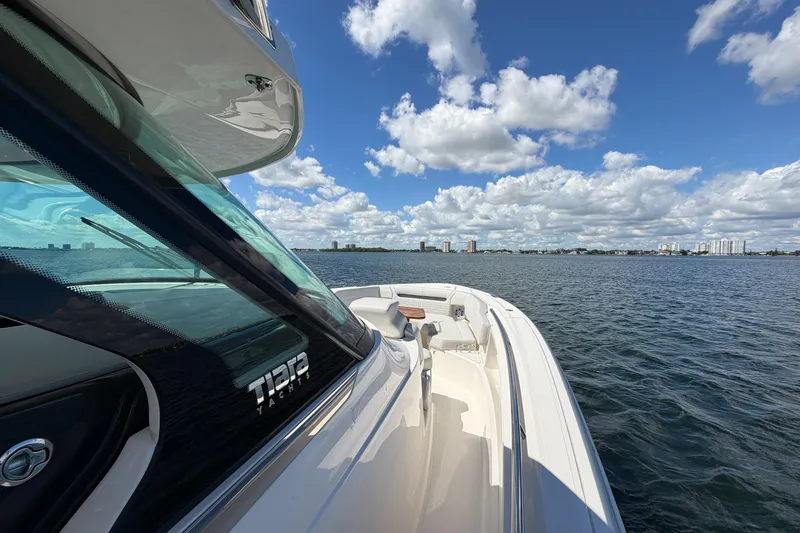 Slide: The Image of 2024 Tiara Yachts 43 LS cruising on a sunny day with city skyline in background. - 30