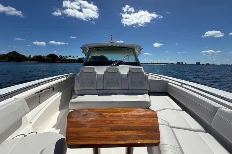 Slide: The Image of 2024 Tiara Yachts 43 LS luxury boat interior with seating and wooden table on a sunny day. - 32