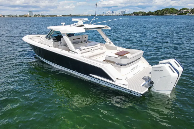 Slide: The Image of 2024 Tiara Yachts 43 LS luxury boat on clear blue water, featuring twin Mercury engines. - 6