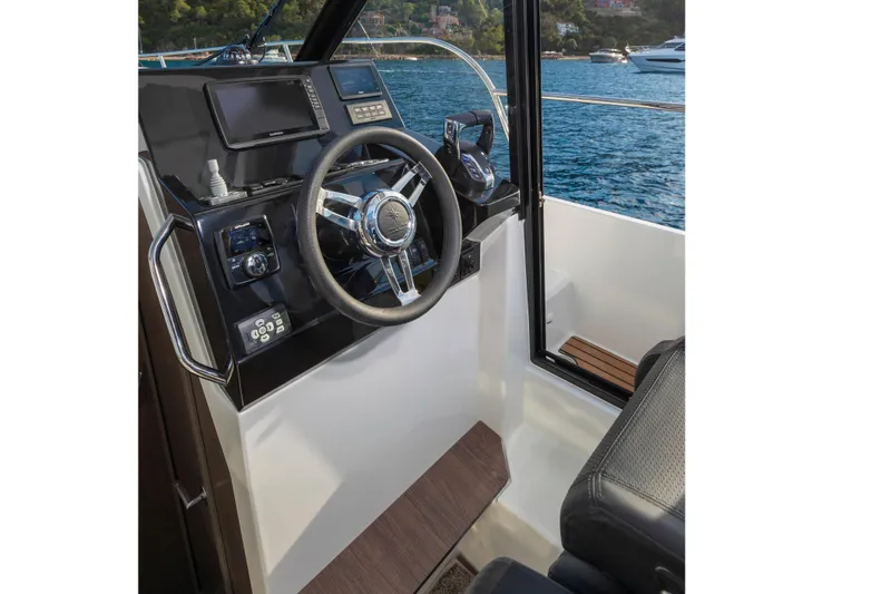 Slide: The Image of Interior helm of 2026 Jeanneau NC 895 Series 2 boat with scenic water view. - 14