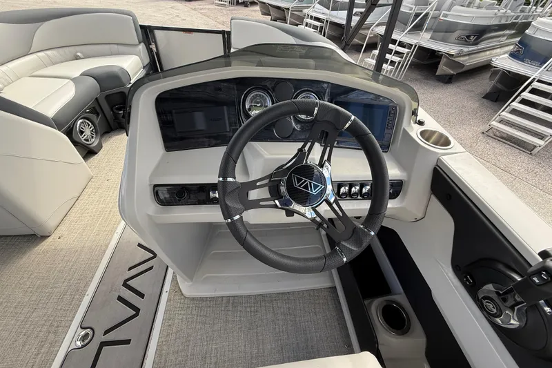 Slide: The Image of 2025 Avalon 2385 LSZ Quad Lounger boat dashboard with modern steering and controls. - 21