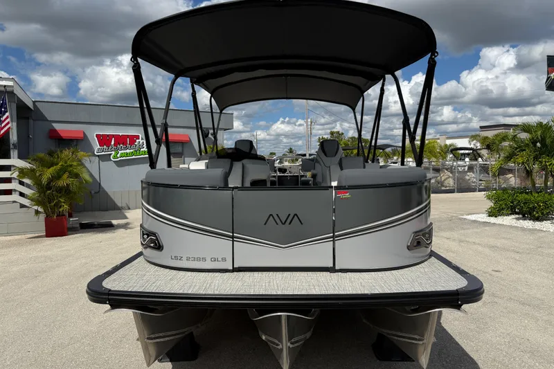 Slide: The Image of 2025 Avalon 2385 LSZ Quad Lounger Tri Toon boat at dealership, showcasing sleek design. - 3