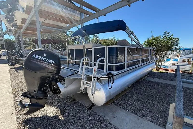 Slide: The Image of 2013 Crest Classic 230 SLC pontoon boat with Mercury outboard motor, docked outdoors. - 1