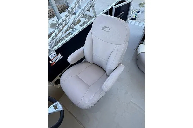 Slide: The Image of 2013 Crest Classic 230 SLC boat seat, beige upholstery, armrests, and logo detail. - 14