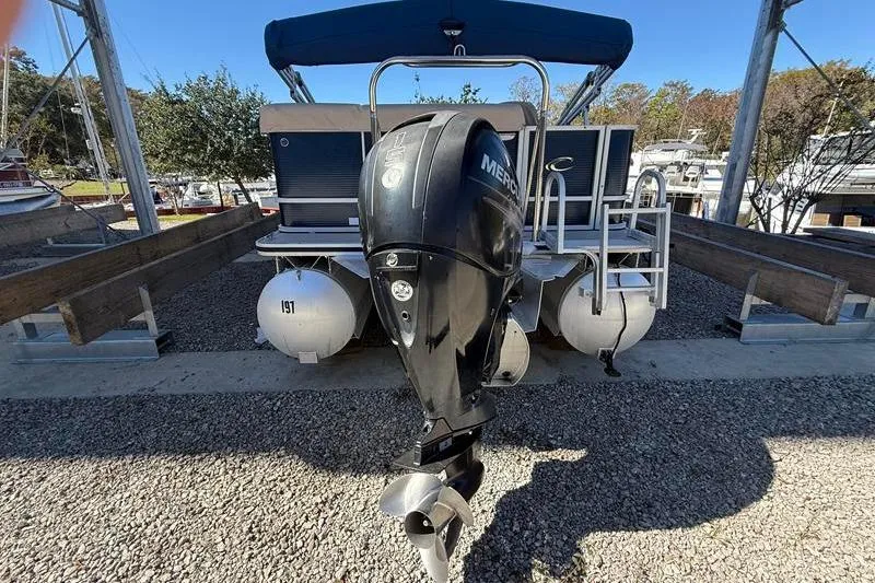 Slide: The Image of 2013 Crest Classic 230 SLC pontoon boat with Mercury outboard motor on gravel. - 2