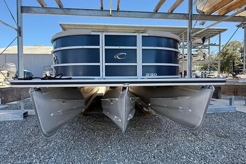 Slide: The Image of 2013 Crest Classic 230 SLC pontoon boat on gravel, under a metal structure. - 5