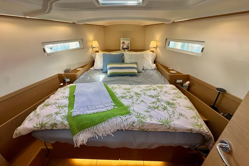 Slide: The Image of Luxurious cabin interior of 2024 Jeanneau Sun Odyssey 410 sailboat, featuring a cozy bed. - 105