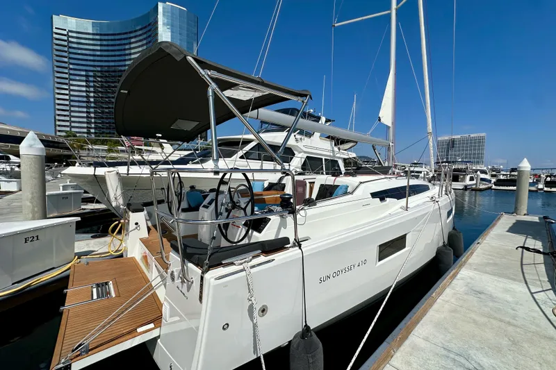 Slide: The Image of 2024 Jeanneau Sun Odyssey 410 sailboat docked at marina, modern design, clear blue sky. - 26