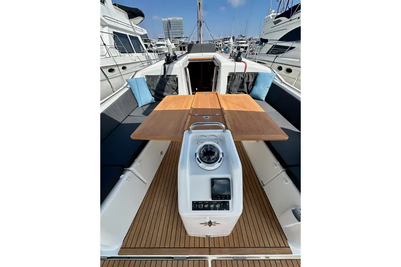 Slide: The Image of 2024 Jeanneau Sun Odyssey 410 sailboat cockpit with wooden table and navigation equipment. - 45