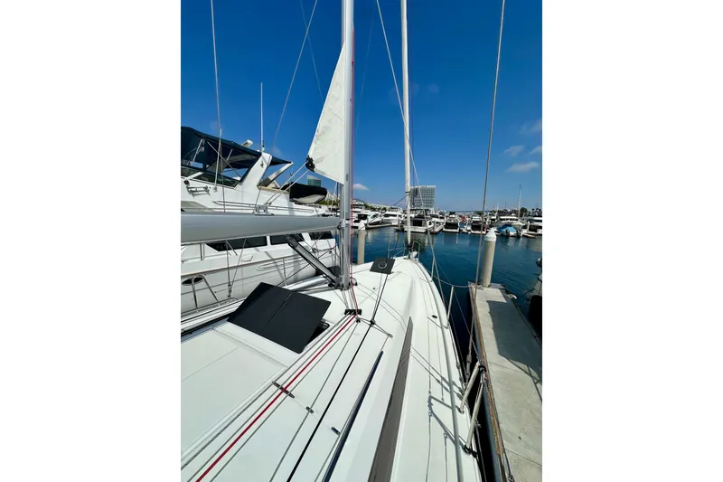 Slide: The Image of 2024 Jeanneau Sun Odyssey 410 sailboat docked in a marina under clear blue skies. - 52