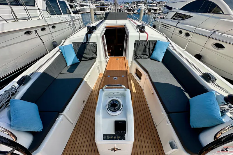 Slide: The Image of 2024 Jeanneau Sun Odyssey 410 yacht cockpit with cushioned seating and teak flooring. - 63