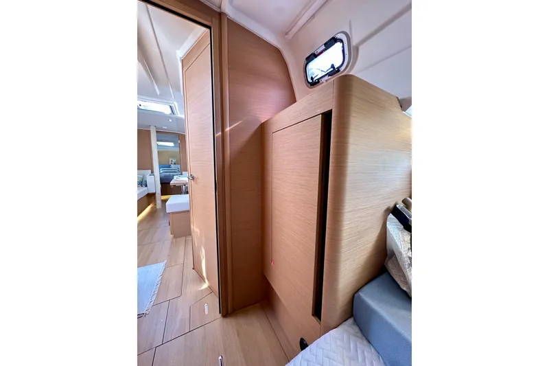 Slide: The Image of Interior of 2024 Jeanneau Sun Odyssey 410 yacht, featuring modern wood finishes and cozy cabin space. - 83