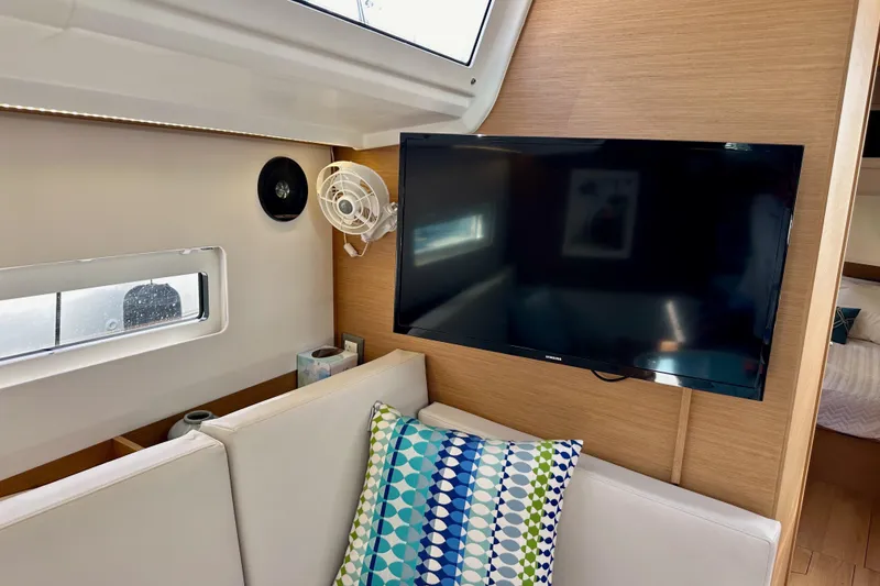 Slide: The Image of 2024 Jeanneau Sun Odyssey 410 interior with TV, fan, and colorful cushion. - 92