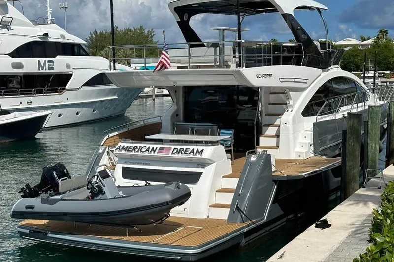 Slide: The Image of Luxury Schaefer 660 yacht docked, featuring sleek design and American flag, 2023 model. - 15