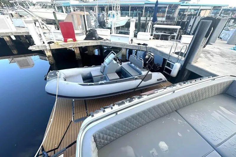 Slide: The Image of 2023 Schaefer 660 inflatable boat docked at a marina with surrounding vessels. - 17