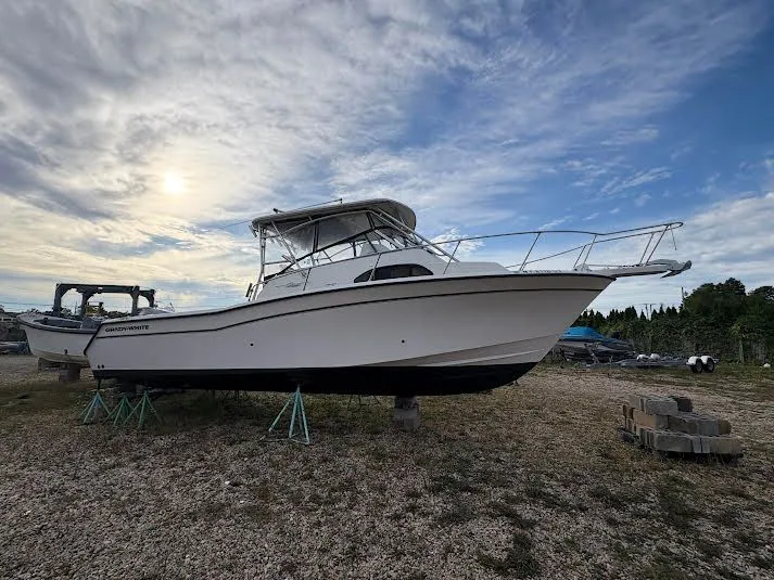 The Image of 2002 Grady-White Marlin 300 boat on stands, under a cloudy sky. - 0