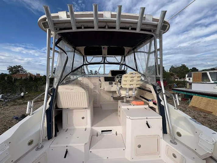 Slide: The Image of 2002 Grady-White Marlin 300 boat interior with seating and helm, under a blue sky. - 10