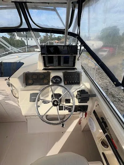 Slide: The Image of 2002 Grady-White Marlin 300 boat cockpit with steering wheel and control panel. - 11