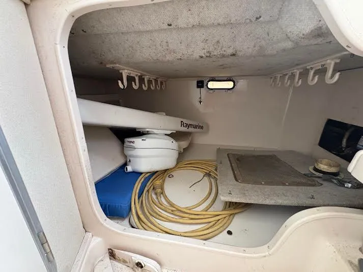 Slide: The Image of 2002 Grady-White Marlin 300 cabin interior with Raymarine equipment and coiled yellow hose. - 15
