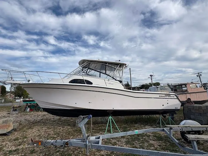Slide: The Image of 2002 Grady-White Marlin 300 boat on land under cloudy sky. - 3