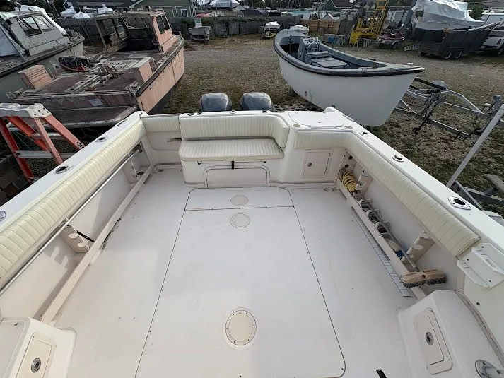 Slide: The Image of 2002 Grady-White Marlin 300 boat deck with seating and storage, docked in a yard. - 8