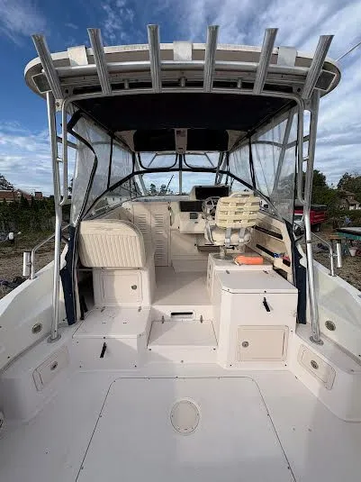 Slide: The Image of 2002 Grady-White Marlin 300 boat interior with seating and helm, under a clear sky. - 9