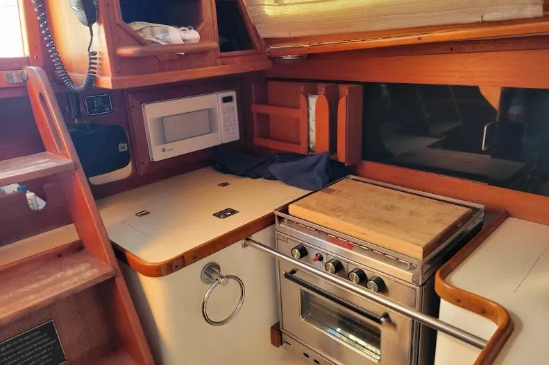 Slide: The Image of Compact kitchen area in a 1988 Freedom Yachts FREEDOM 36 galley featuring the microwave, top-loading refrigeration, 3-burner propane gimbaled stove - 11