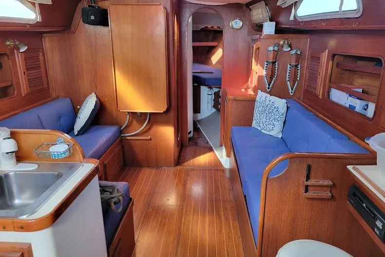 Slide: The Image of Interior of 1988 Freedom Yachts FREEDOM 36, featuring wooden finishes and blue seating. - 18