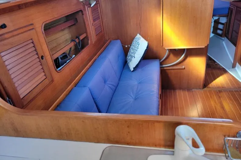 Slide: The Image of Interior of 1988 Freedom 36 yacht with blue seating and wooden cabinetry. - 19