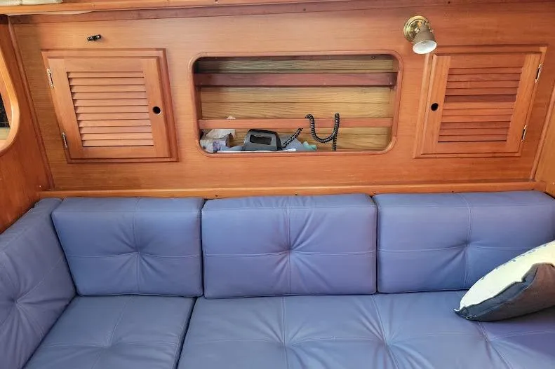 Slide: The Image of Interior of 1988 Freedom 36 yacht with blue seating and wooden cabinetry. - 20