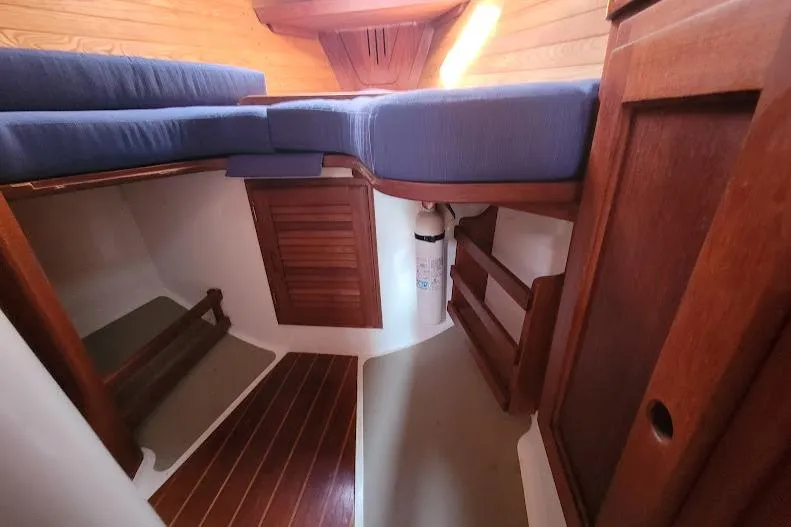Slide: The Image of Cozy cabin interior of 1988 Freedom Yachts FREEDOM 36 with wooden finish and blue cushions. - 23