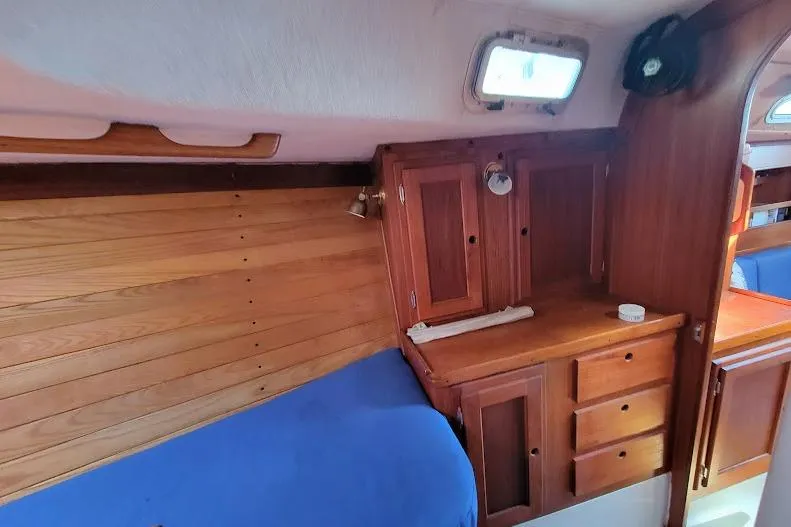 Slide: The Image of Interior of 1988 Freedom 36 yacht with wooden cabinetry and blue bedding. - 24