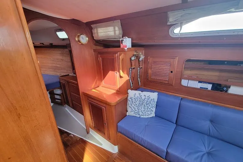 Slide: The Image of Interior of 1988 Freedom Yachts FREEDOM 36, featuring wooden cabinetry and blue seating. - 25