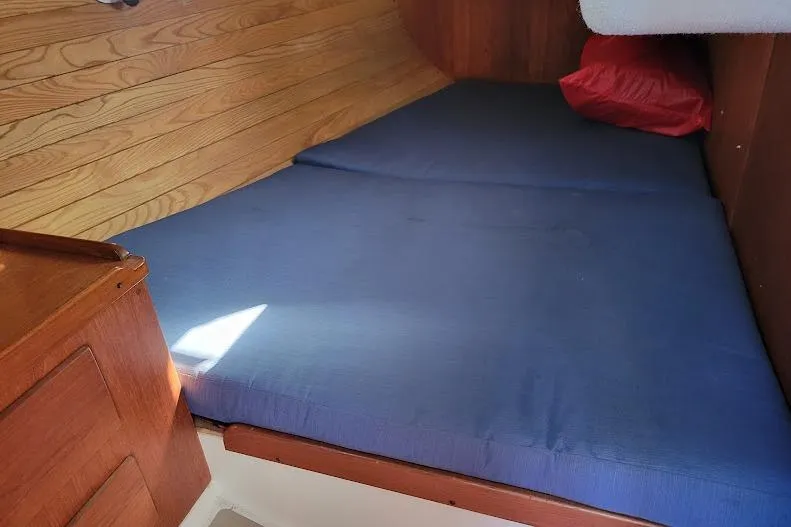 Slide: The Image of Cozy cabin interior of 1988 Freedom 36 yacht with blue mattress and wooden paneling. - 31