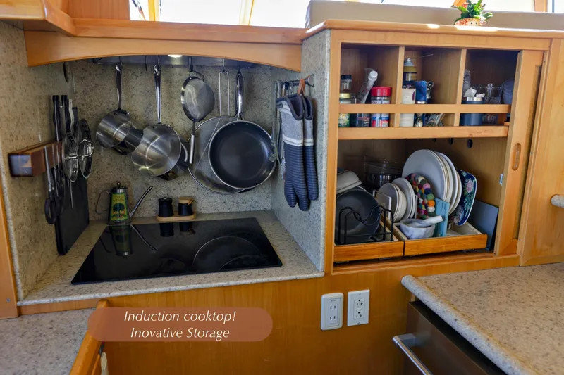 Slide: The Image of Kitchen area of 2004 McKinna 57 Pilothouse with induction cooktop and organized storage. - 19