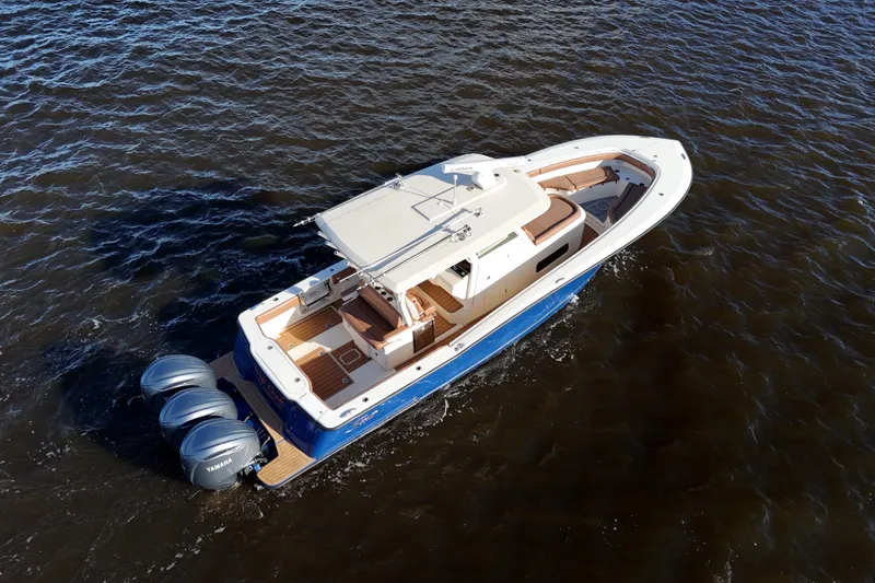 Slide: The Image of 2017 Scout 350 LXF boat cruising on open water, featuring triple Yamaha engines. - 10