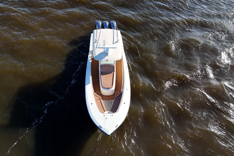 Slide: The Image of 2017 Scout 350 LXF boat on water, aerial view, showcasing sleek design and triple engines. - 12