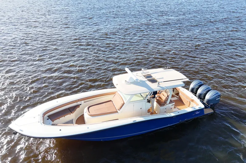 Slide: The Image of 2017 Scout 350 LXF boat on water, featuring triple outboard engines. - 15