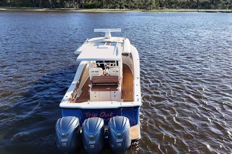 Slide: The Image of 2017 Scout 350 LXF boat with triple engines on a calm lake. - 16