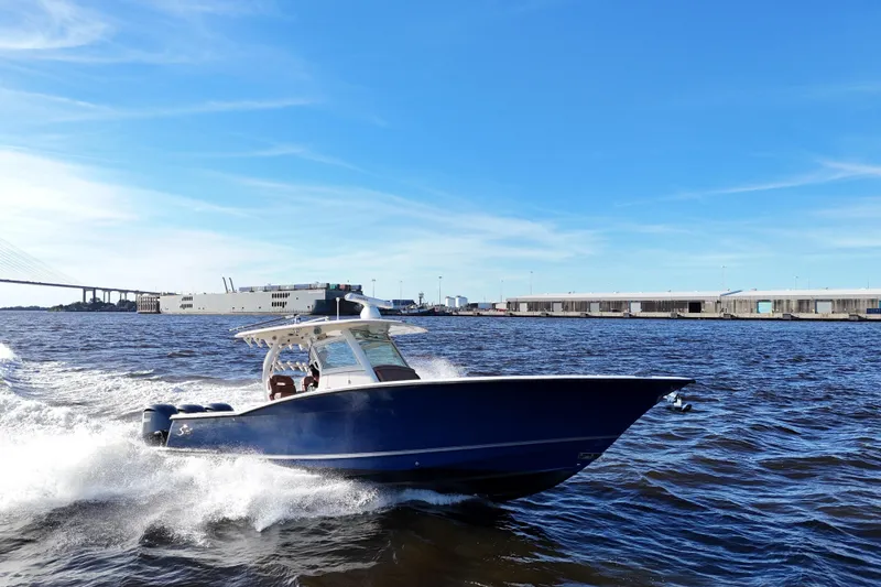 Slide: The Image of 2017 Scout 350 LXF boat cruising on open water under clear blue skies. - 19