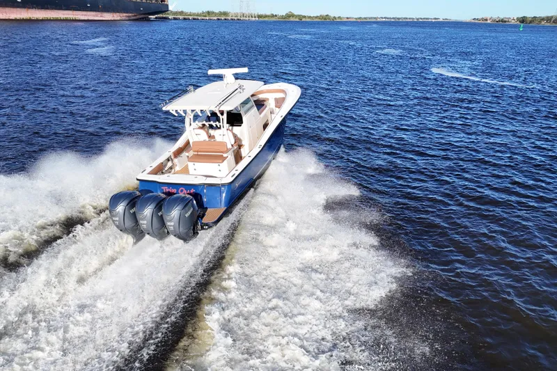 Slide: The Image of 2017 Scout 350 LXF boat cruising on open water with triple engines. - 28