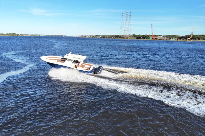 Slide: The Image of 2017 Scout 350 LXF boat cruising on a sunny day, creating waves in the water. - 30