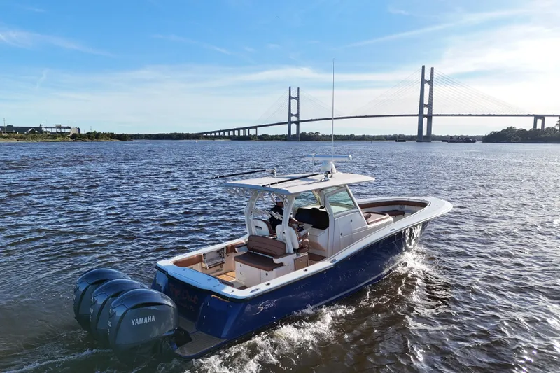 Slide: The Image of 2017 Scout 350 LXF boat cruising near a bridge on a sunny day. - 31