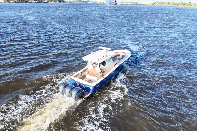 Slide: The Image of 2017 Scout 350 LXF boat cruising on open water, rear view. - 36