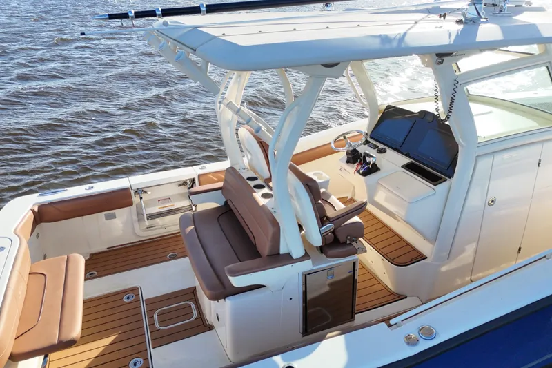 Slide: The Image of 2017 Scout 350 LXF boat interior with brown seating and modern dashboard on water. - 40