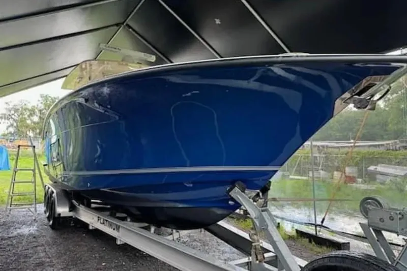 Slide: The Image of 2017 Scout 350 LXF boat on trailer under shelter, side view. - 53