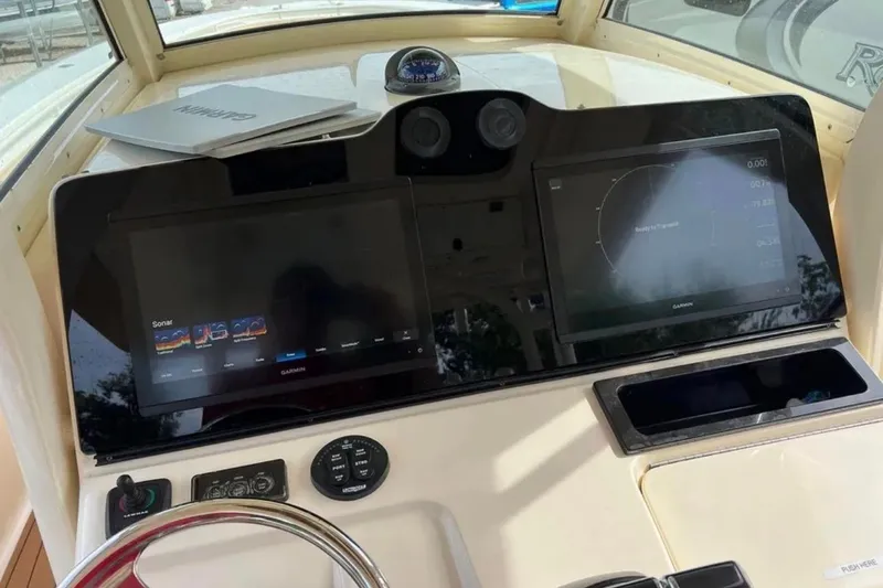 Slide: The Image of 2017 Scout 350 LXF boat dashboard with Garmin navigation screens and controls. - 59