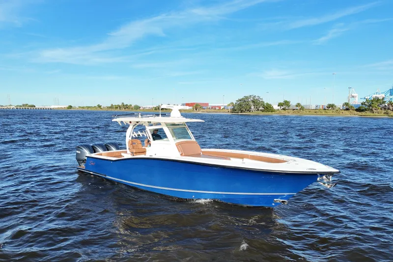 Slide: The Image of 2017 Scout 350 LXF boat on water, blue hull, twin Yamaha engines, clear sky. - 6